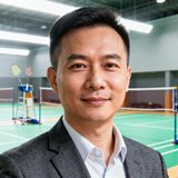 广州羽跃体育连锁场馆运营总监陈总在羽毛球馆内的半身照，背景是明亮的羽毛球场地